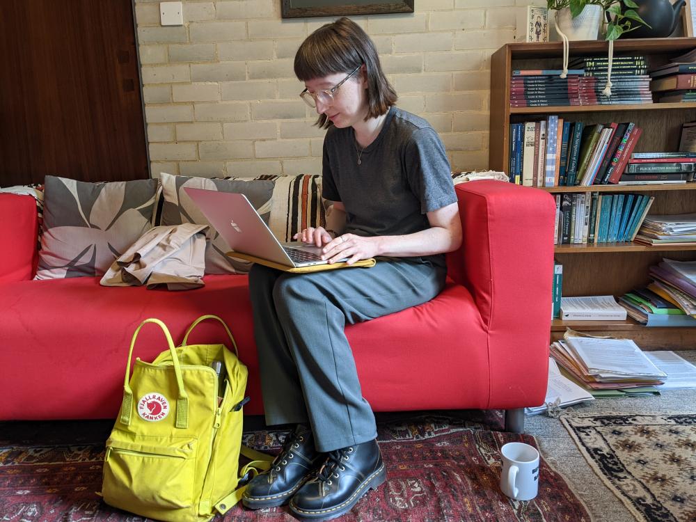 Student sitting on a sofa with a laptop